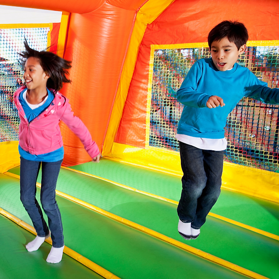 Kids playing on a colorful inflatable obstacle course at an outdoor event